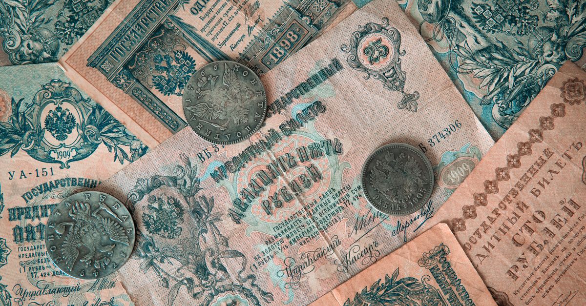 Collection of vintage Russian banknotes and coins featuring intricate designs.